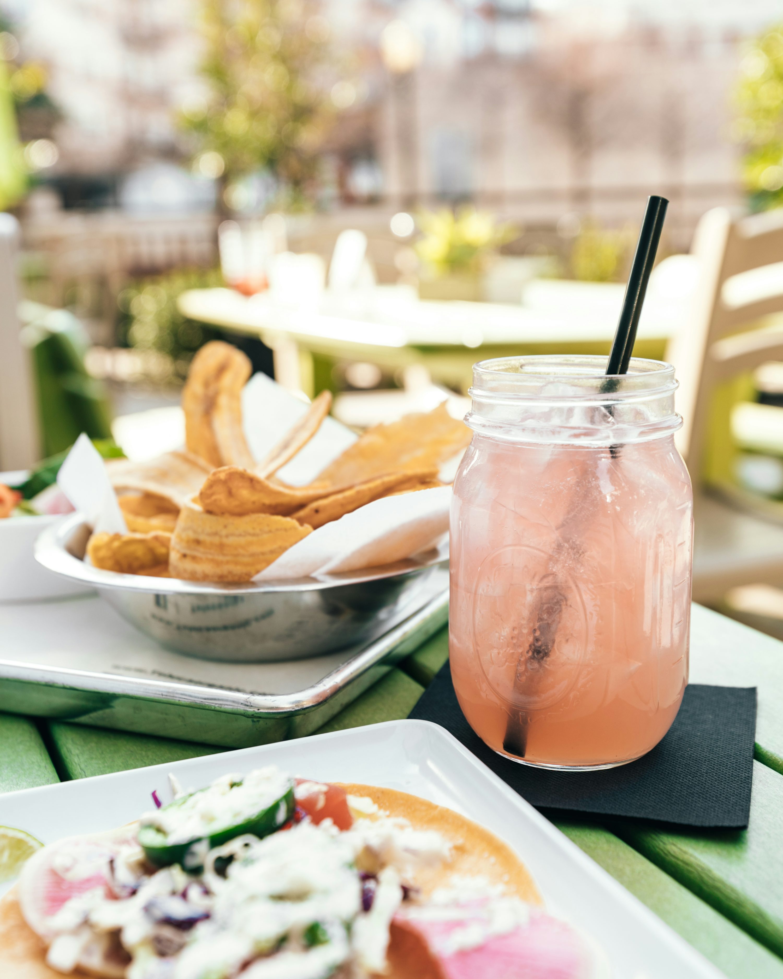 Dessert and a pink drink on a sunny restaurant table