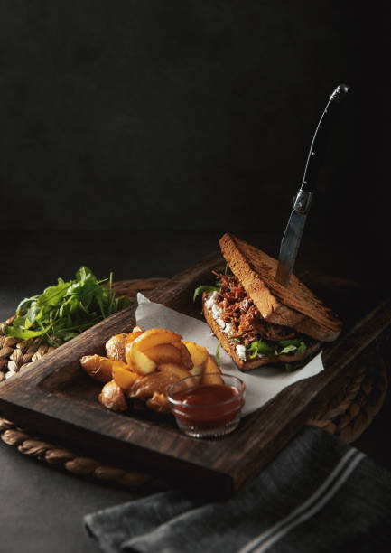 A plated burger and fries on a dark restaurant table